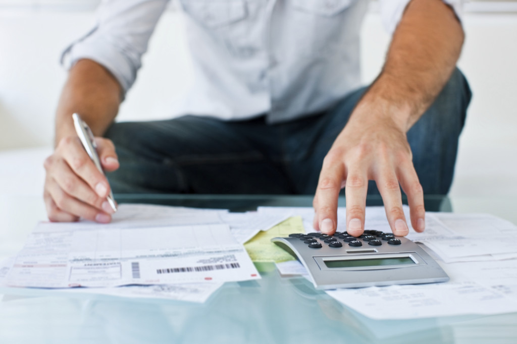 Cropped image of a man calculating his bills