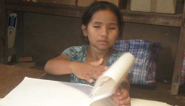 Blind child reading her book