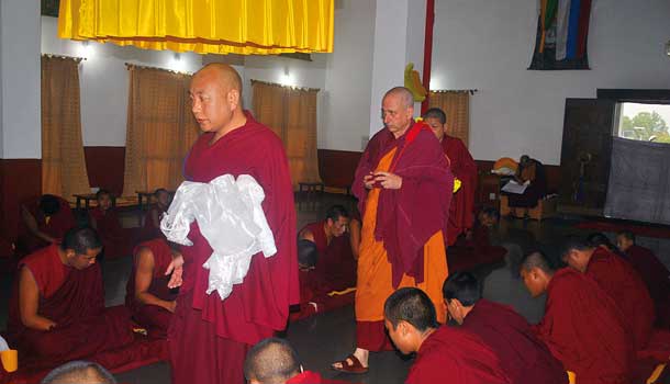 Having made prostrations at the door of the temple, Nicky walks down a central row of monks